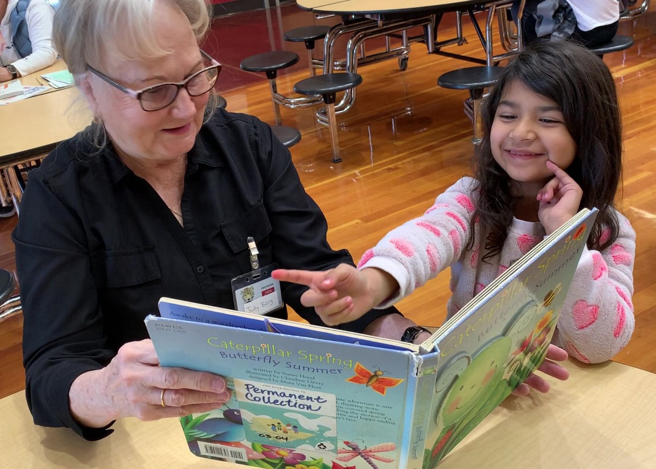 A SMART volunteer reading with a student